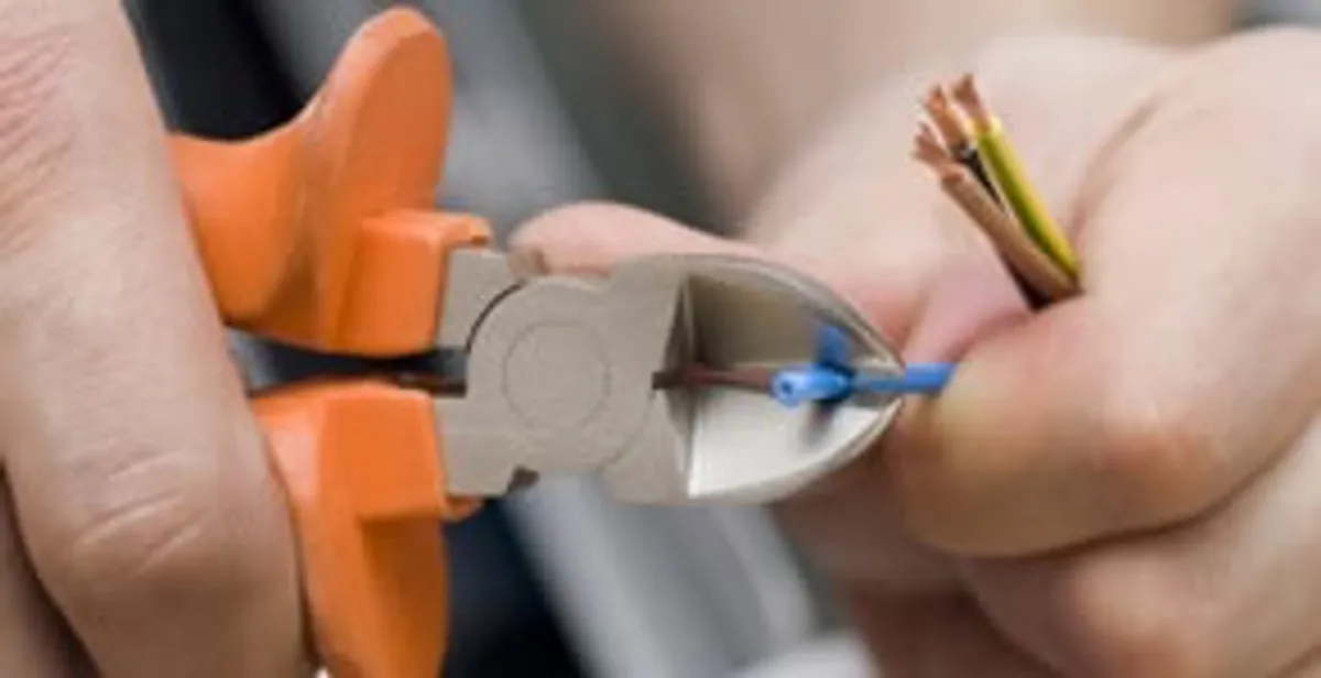 licensed electrician performing precise wire cutting and preparation during electrical service in Miami, FL