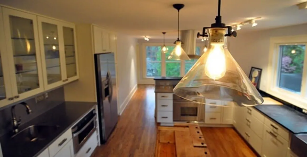 Residential electrician installing modern indoor light fixture in a home in Miami, FL